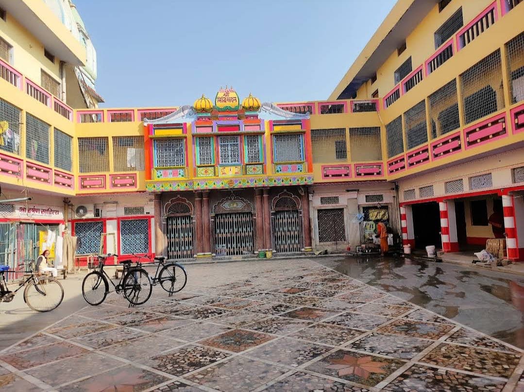 Yellow and pink painted courtyard building with marble floor and parked bicycles