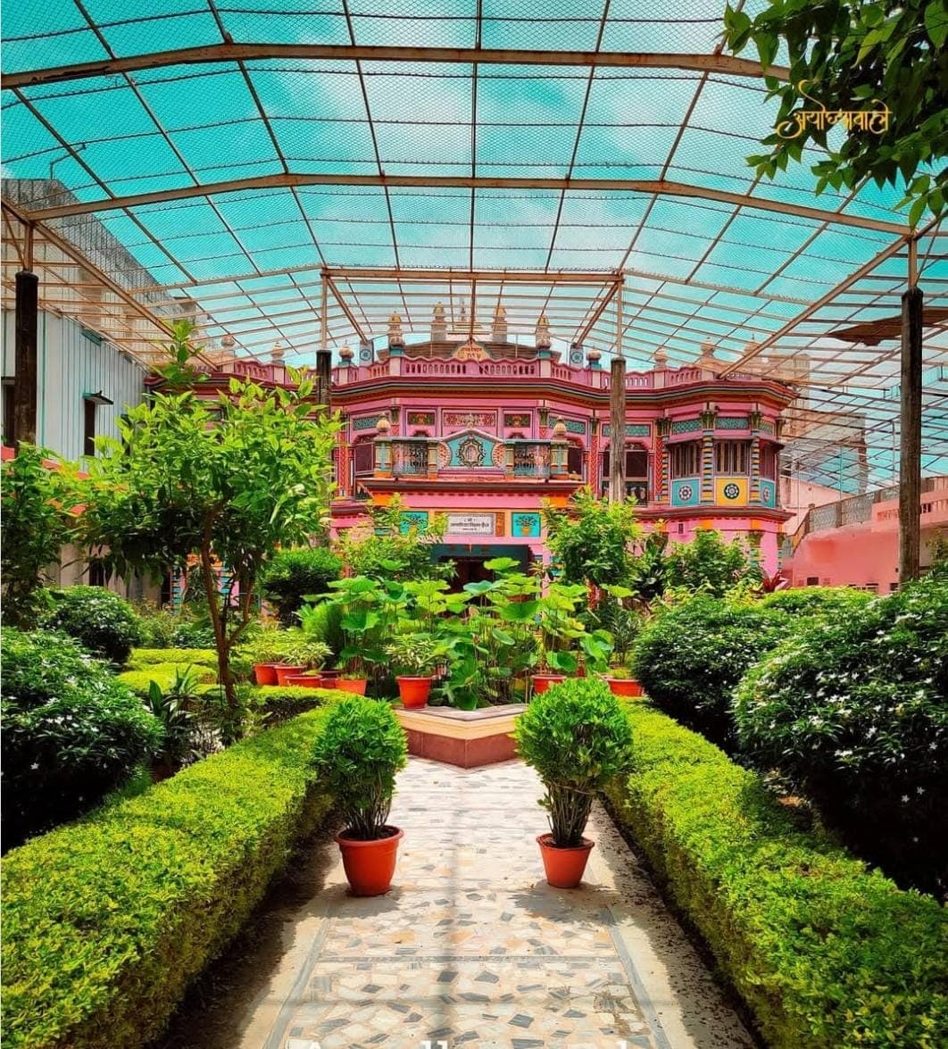 Painted pink haveli of Sri Janaki Mahal seen across the lotus garden